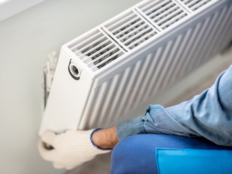 Man-installing-central-heating-radiator